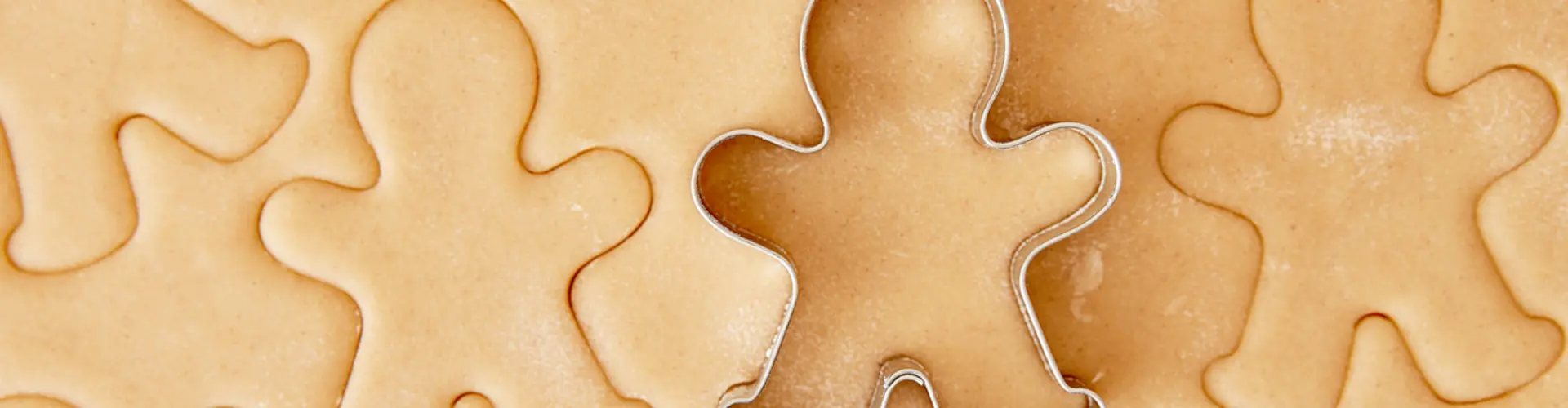 Cookie dough and a cookie cutter in the form of a gingerbread figure
